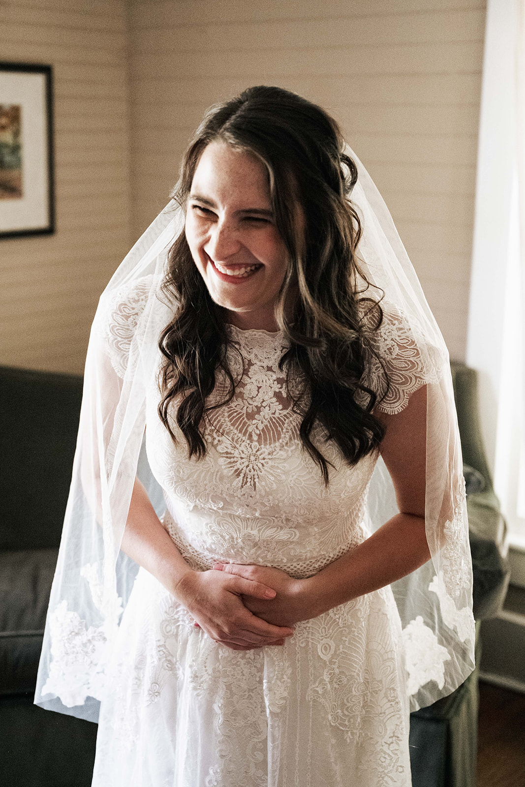 Bride giggles with excitement before the first look with her bridesmaids.